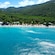 A tropical beach in Saint Thomas with a serene sea and some small buildings on the sandy shore